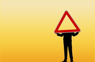 man holding warning-yield traffic sign